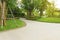 The gray curve pattern walkway, sand washed finishing on concrete paving, brown gravel on border, a smooth green grass lawn, trees