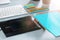 The gray desk with laptop, notepad with blank sheet, pot of flower, stylus and tablet for retouching