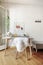 Gray desk with white goat hair chair with coat rack on the wall,