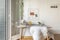 Gray desk with white goatskin chair with coat rack on the wall, hanging