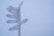 Gray direction sign pointing on capitals of countries on a gray foggy sky background.