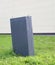 Gray electrical switchboard on the covered grass of the lawn