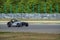 A gray fast sports car drives along a racing circuit.