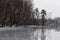 Gray frozen lake covered with a thin layer of mirror water