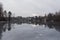 Gray frozen lake covered with a thin layer of mirror water