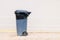 Gray garbage container with garbage bag  on light background, trash can