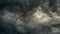 gray gloomy sky before the storm with unusual bizarre patterns of dense cumulus clouds and back light. panoramic view. Artistic
