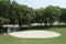 gray gravel circle baseball diamond with road behind and trees, silver diamond