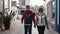 Gray haired family couple of American tourists walks together on Ericeira street