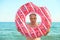 Gray-haired funny man swims on inflatable circle in the sea