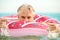 Gray-haired funny man swims on inflatable circle in the sea