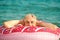 Gray-haired funny man swims on inflatable circle in the sea