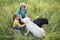 Gray-haired grandmother and cute little granddaughter are walking their dogs together in the park