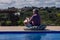 Gray-haired man between 50 and 60 years old playing a handpan on a sunny