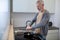 A gray-haired man cooking omlette in the kitchen