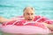 Gray-haired man swims on an inflatable circle in the sea