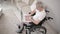 Gray Haired Man in a Wheelchair in His Ward Sitting at a Laptop.