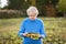 The gray-haired woman of seventy years cleans the ripened sunflower