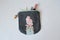 Gray handmade zipper pouch with cute doll, hair pins, mascara and hair tweezers