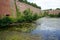 The gray heron hunts in a moat near Spandau Citadel in August. Berlin-Spandau, Germany.