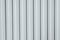 Gray iron construction profiled sheet with vertical stripes. Textured background. Corrugated building material for fences and