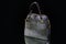 Gray ladies bag on a black background with handles and a clasp.
