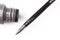 Gray liquid eyeliner brush close-up macro with a tube