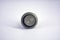 Gray metal button with contacts for switching and inclusion of 220V or 12V network located on a white plastic background.