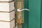 gray metal door handle with a mortise lock on a green iron door