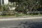 Gray metal fence with a broken section on the street near the curb and asphalt road