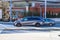 A gray mini van surrounded by other cars in front of a red brick building in downtown Atlanta