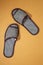 Gray one-off slippers for hotel on a color background