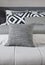 Gray pillow on bench with monotone bedding