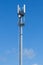 Gray pipe telecommunication tower on blue sky background, Vertical shot