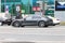 Gray Porsche Taycan on the city road. Fast moving car on the street. All-electric car driving along the street in city with