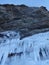 Gray rocks with icicles. The Baikal shore in winter