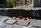 Gray rough stone balustrade closeup. ornate motif. dry autumn leaves