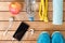 Gray running shoes and sports accessories on wooden background .