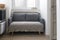 Gray soft sofa with 2 pillows.