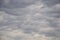 Gray stormy sky with cumulus clouds. Picturesque overcast sky with many clouds. Air clouds background, full frame. Copy space.