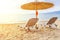 Gray straw umbrella on beautiful beach and ocean with burning sun