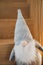 Gray stuffed Scandinavian gnome toy on wooden stairs