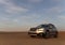 Gray Subaru in the sand of the Namib desert at a bright sky