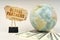 On a gray surface, a globe, dollars and a cardboard plate with the inscription - GLOBAL PARTNERS