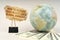 On a gray surface, a globe, dollars and a cardboard plate with the inscription - How to manage your money amid global