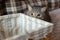Gray thoroughbred British cat hid behind basket. Look of cat predator