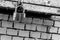 Gray urban background toning closed hinged iron lock on brick wall background close-up of grunge base