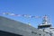 A gray warship fragment decorated with a row of colorful nautical flags