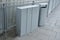 Gray waste bin for three parts of waste with three holes for the separation of paper, plastic and glass in the square, platform. t