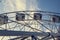 Gray or white metal ferris wheel with closed passenger cabins close-up in the amusement park